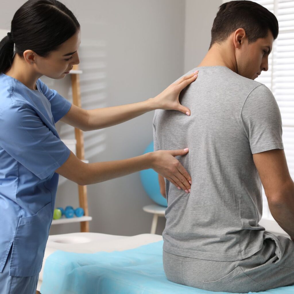 physical therapist feeling patient's back